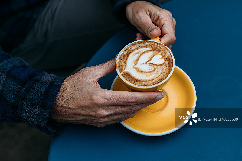 手捧拿铁咖啡的男人图片素材