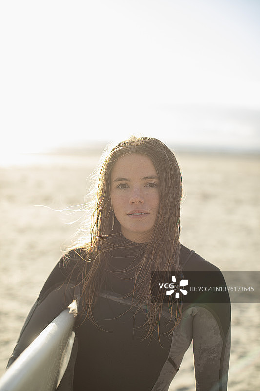 年轻冲浪女郎在阳光明媚的沙滩上图片素材