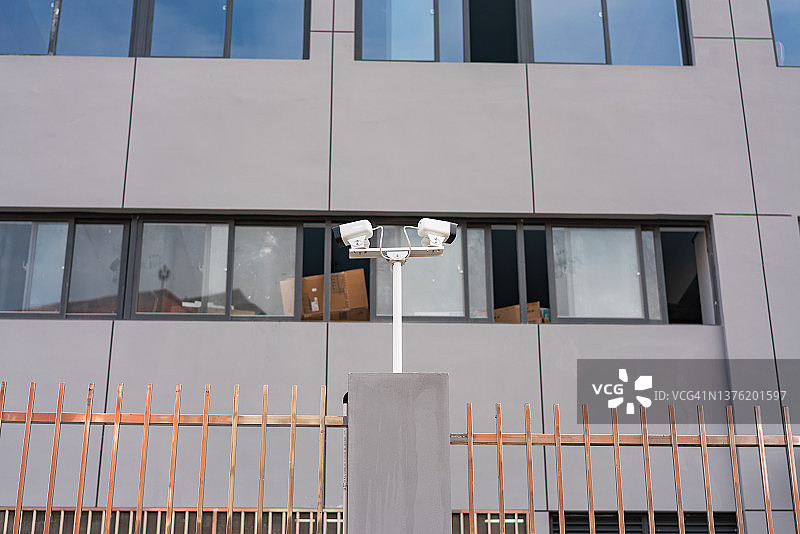工厂围栏上的两个监控摄像头图片素材
