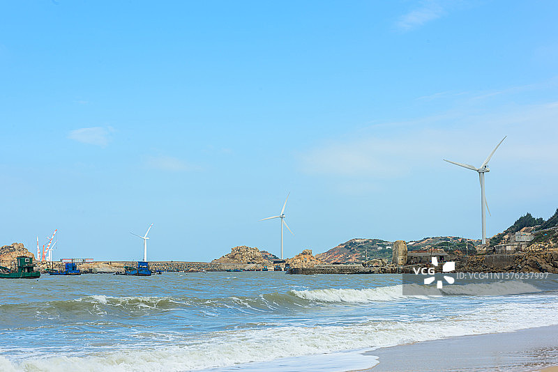 岛上的风力涡轮机和浪潮信息图片素材
