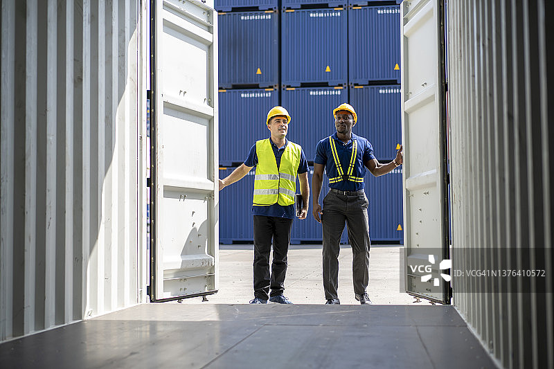 工头检查货运集装箱。工头和工作人员正在打开集装箱进行检查图片素材