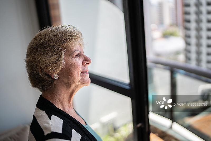 高龄女性望向别处，凝视家中图片素材