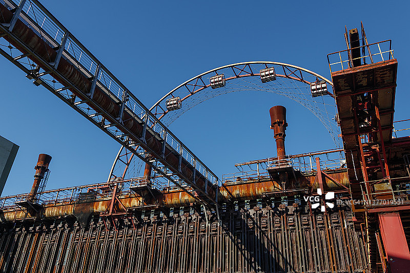 前煤矿中带有复杂拱顶、管道和公用设施的旧锈机器图片素材