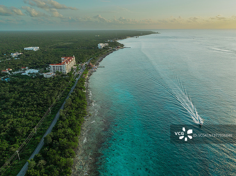日落时分科苏梅尔岛和卡门海滩附近的快艇鸟瞰图图片素材