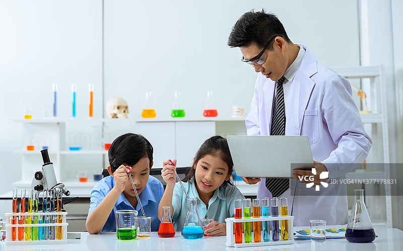 两个孩子在做科学实验。孩子们在学校实验室里学习化学图片素材