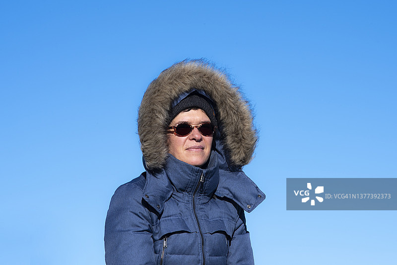 身穿冬装，蓝天下女子肖像图片素材