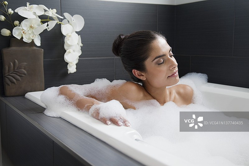年轻女人在浴缸中放松图片素材