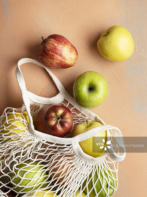 购物袋中的成熟苹果，彩色背景上的苹果图片素材