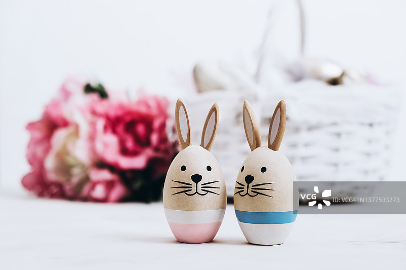 两只复活节兔子与玫瑰花束和篮子图片素材