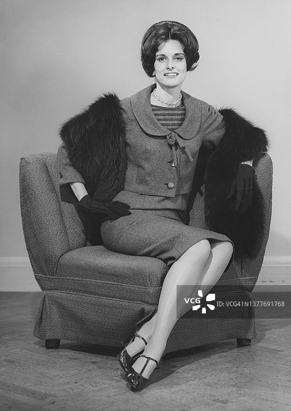 衣着讲究的女人坐在扶手椅上图片素材