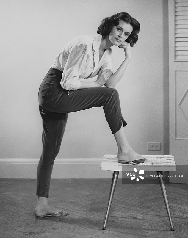 女人把一条腿放在凳子上图片素材