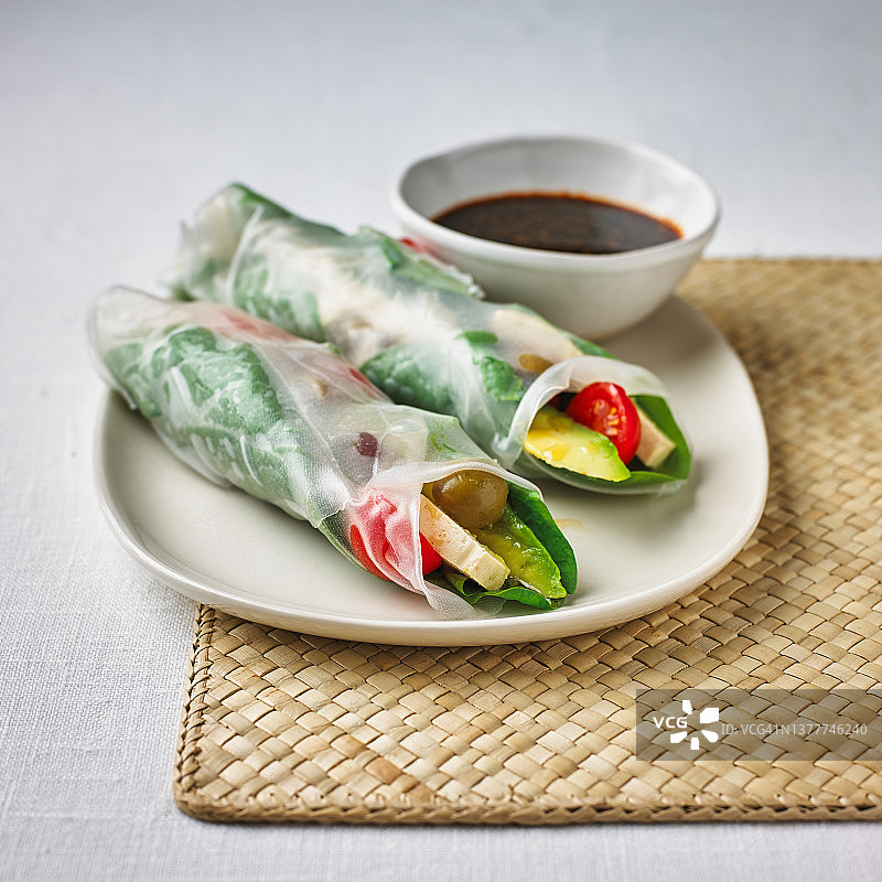 搭配枫糖酱油和辣椒酱的打开的米纸卷，V1图片素材