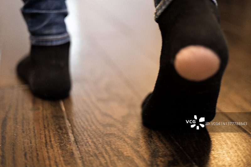 女人在家里穿着脚后跟破洞的袜子走路图片素材