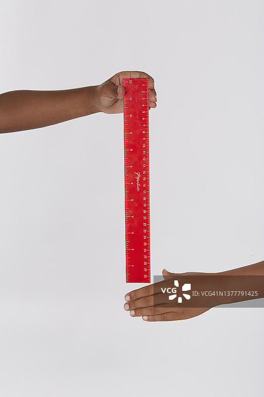反应测试中双手握着红色尺子图片素材