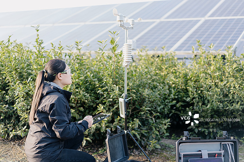 农业科学家在太阳能发电站记录气象数据图片素材