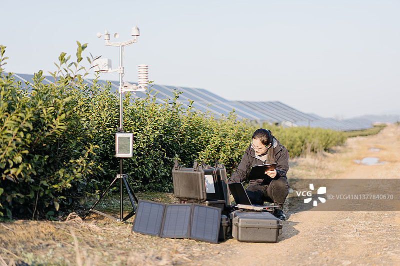 农业科学家在太阳能发电站记录气象数据图片素材
