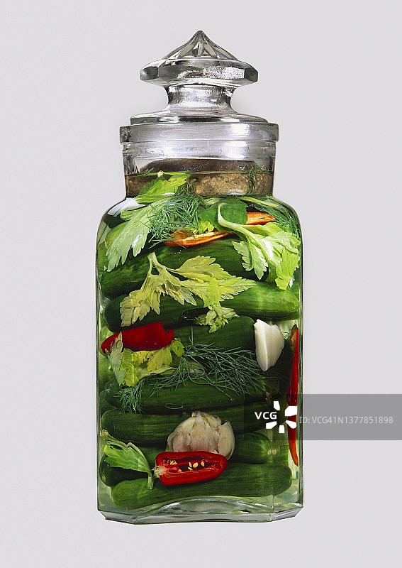 装有绿色腌制小黄瓜和红辣椒的罐子图片素材