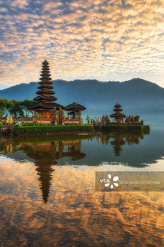 清晨巴厘岛布拉坦湖上的水神庙，周围环绕着山脉，营造出一种神秘的精神氛围图片素材