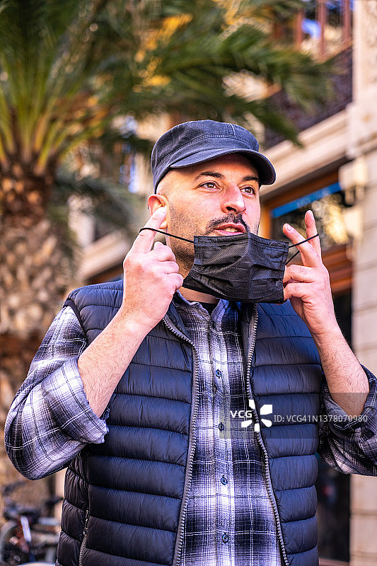 疫情结束后，充满希望的男人在街上自由摘下口罩图片素材