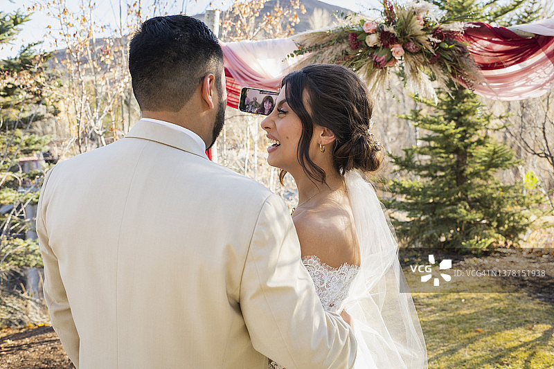 婚礼上与家人直播互动的新娘新郎图片素材