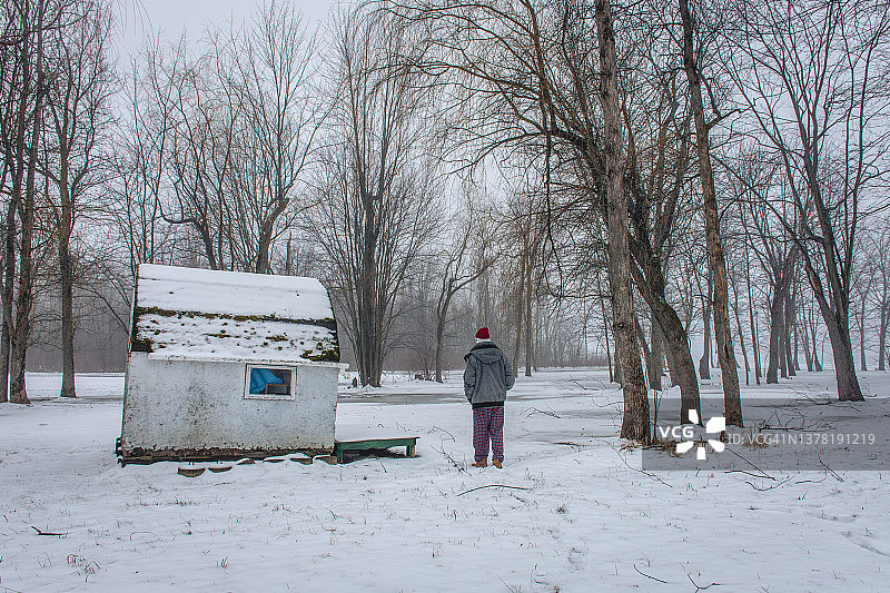 男子在雪中走向棚屋图片素材