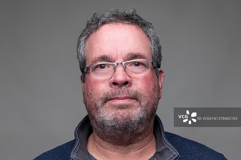 未刮胡须的中年男人看着镜头的正面照图片素材