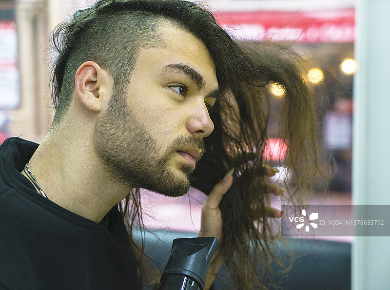 男子正在用吹风机做发型图片素材