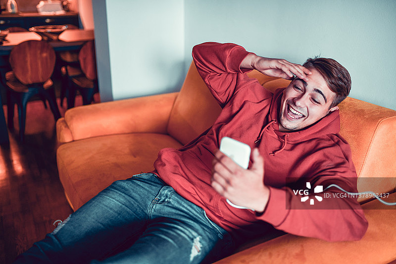 快乐的男人在家用智能手机进行有趣的视频会议图片素材