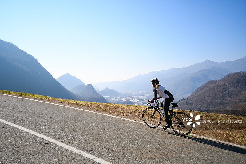在意大利阿尔卑斯山路上骑公路自行车的女人图片素材