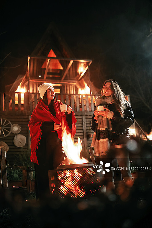 两个朋友在火炉旁喝咖啡，女性生活方式图片素材