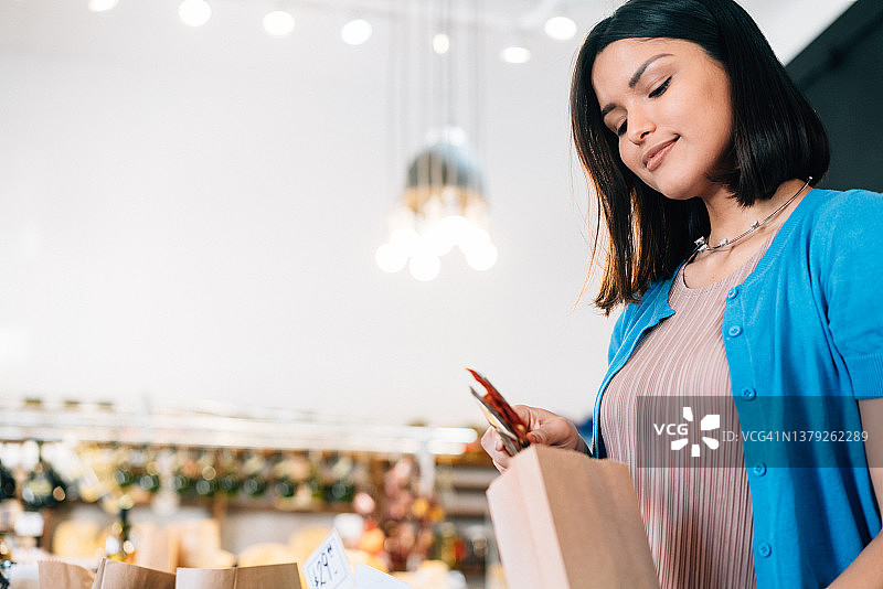 年轻的拉丁裔女人在熟食店购物图片素材
