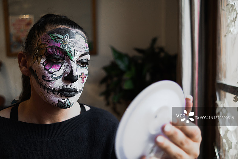 万圣节相关戏剧开演前，在化妆间用油彩化妆的戏剧女演员特写图片素材