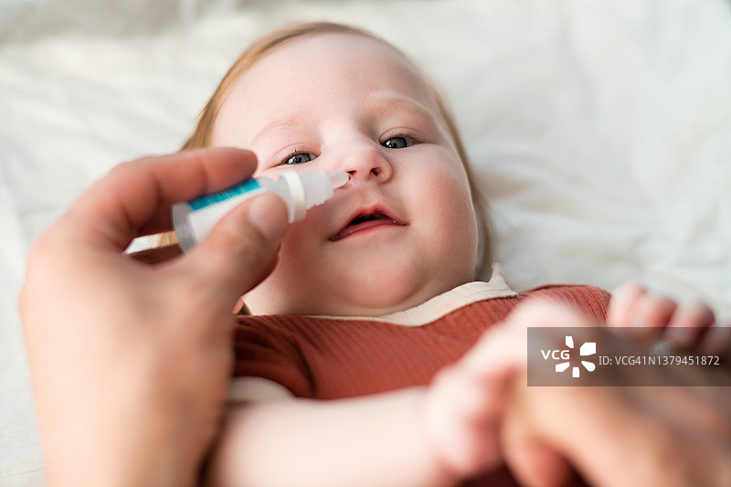 父亲给女婴滴鼻图片素材