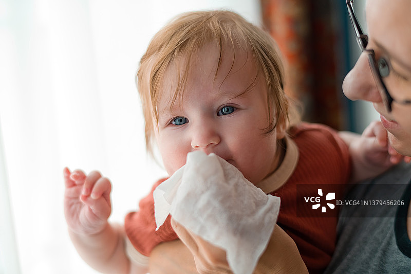 妈妈清洁女婴的鼻子图片素材