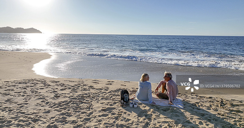 航拍一对中年夫妇在海滩上散步图片素材