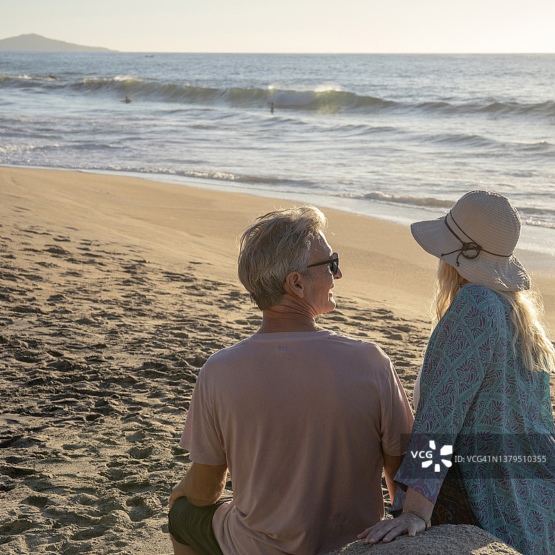 年长的夫妇在早晨的沙滩上放松图片素材