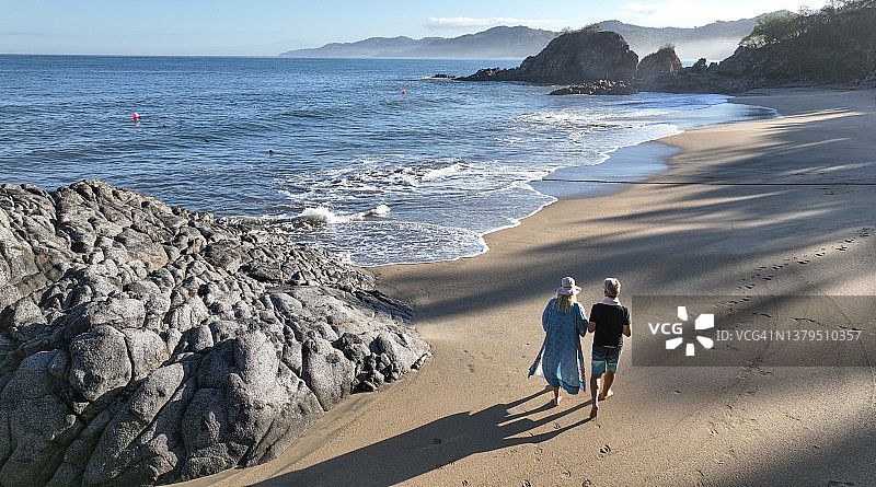 航拍一对中年夫妇在海滩上散步图片素材