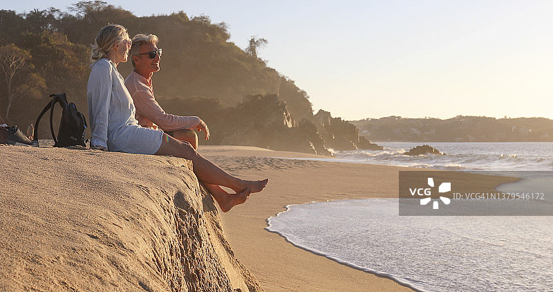 年长的夫妇在早晨的沙滩上放松图片素材