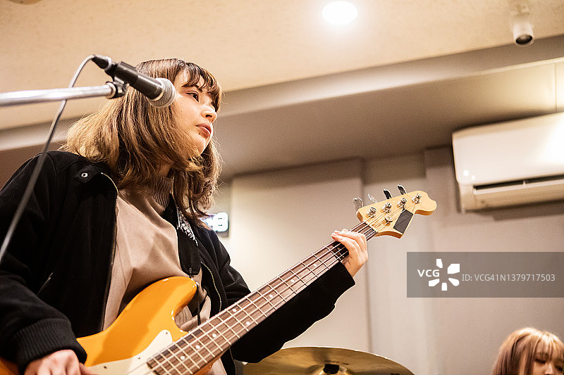 女子乐队中的贝斯手与朋友在音乐工作室练习图片素材