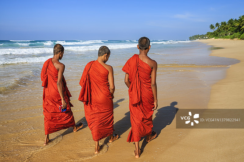 斯里兰卡青年佛教僧侣在海滩上行走图片素材