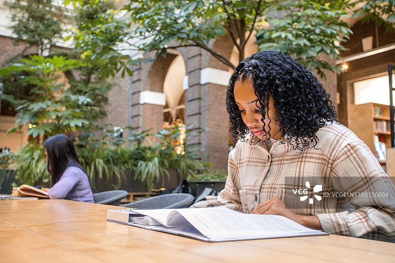 在公共图书馆学习的漂亮黑人少女学生图片素材