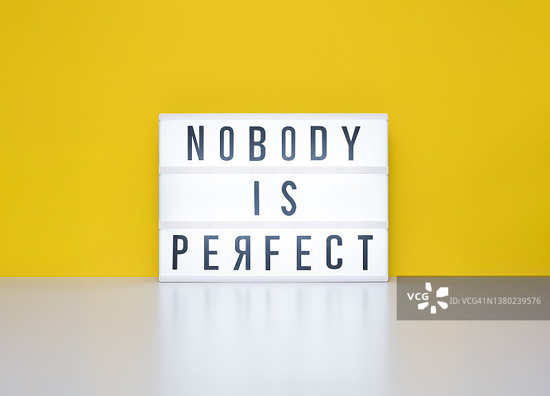 灯箱上显示“没有人是完美的”，字母“R”是反向的图片素材