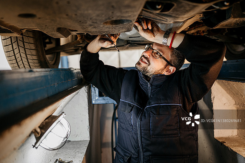 汽修工在车底修理汽车图片素材
