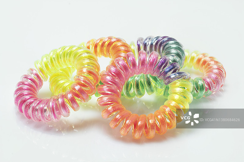 白色背景下不同颜色的螺旋弹性橡皮筋图片素材