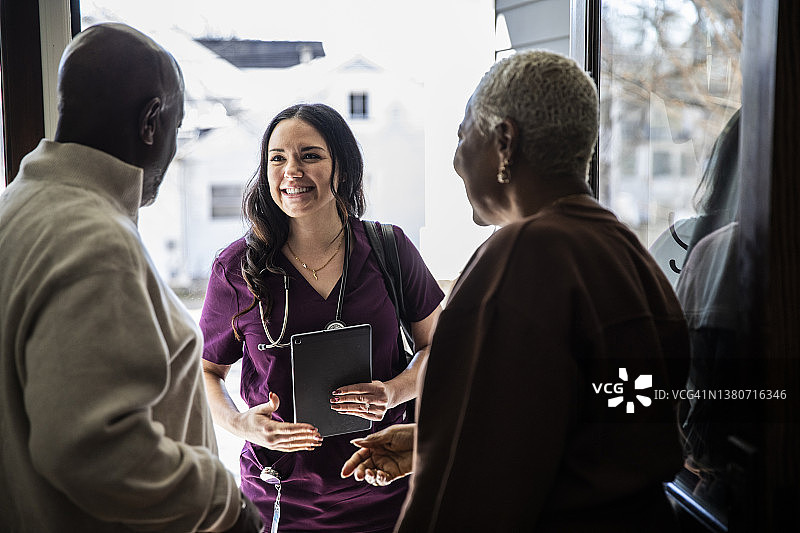 老年夫妇在家门口迎接上门护士图片素材