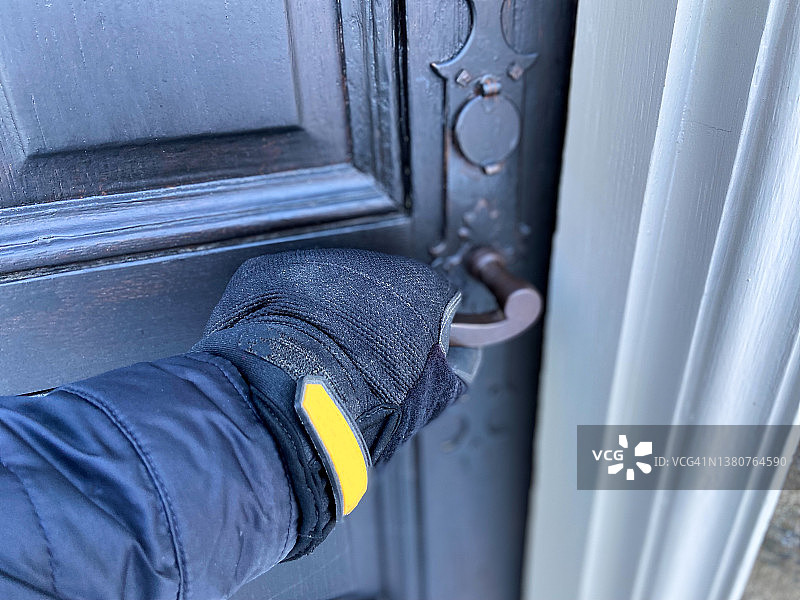戴手套的男人打开家门图片素材