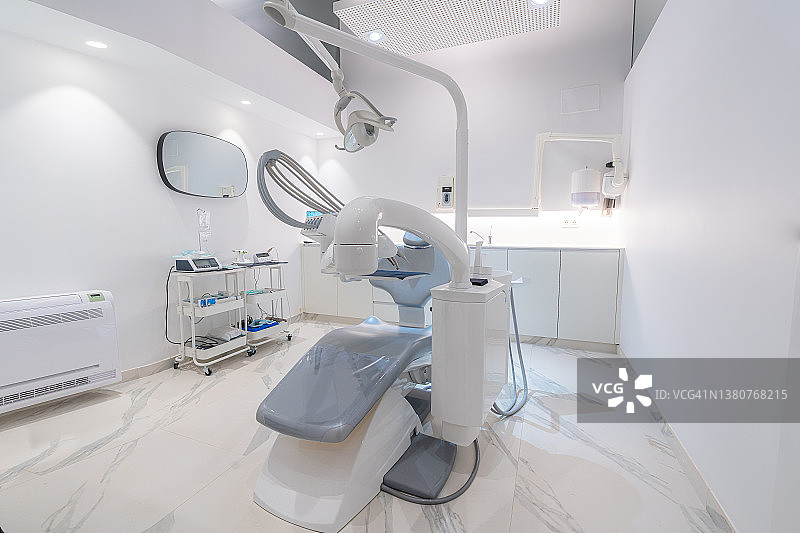 现代牙科诊所的设施：带有椅子、灯、屏幕和口腔科工具的牙科诊室内部图片素材