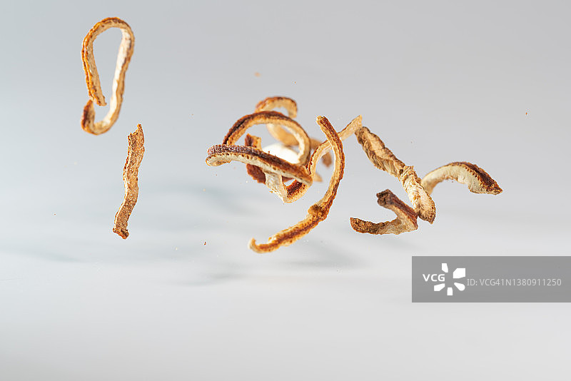 白色背景中飞舞的橙色果皮图片素材