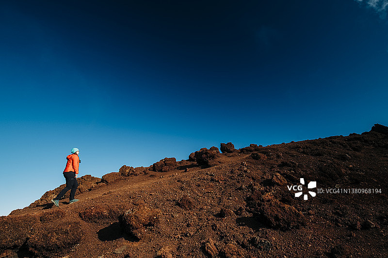 健壮的女人徒步登上冒纳凯阿火山的山脊图片素材