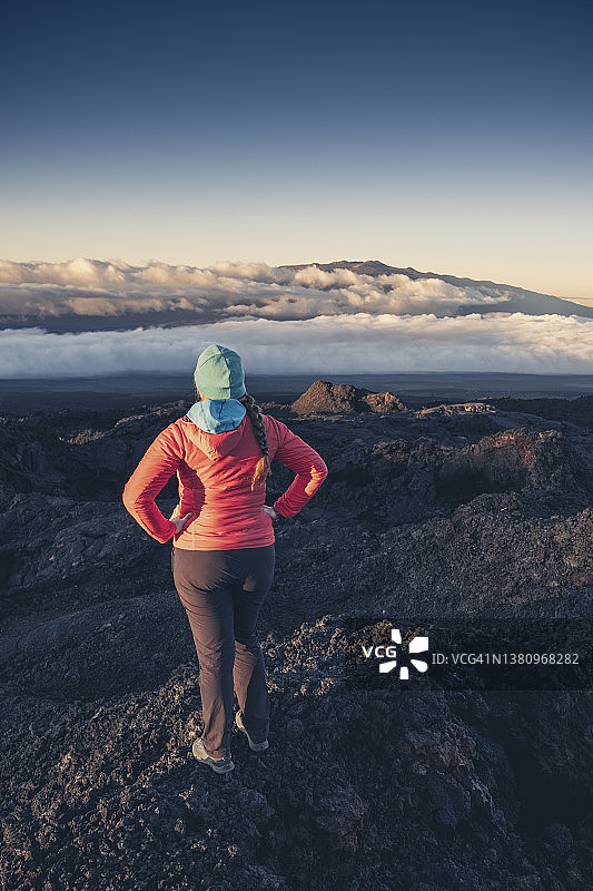 在夏威夷火山上看日落云海的女人图片素材